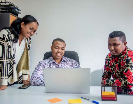   Réunion de collaborateurs travaillant ensemble autour d'un ordinateur pour discuter de projets et de stratégies.